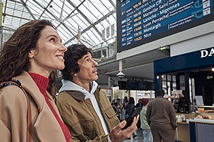 Image d'un couple qui regarde le tableau des gares